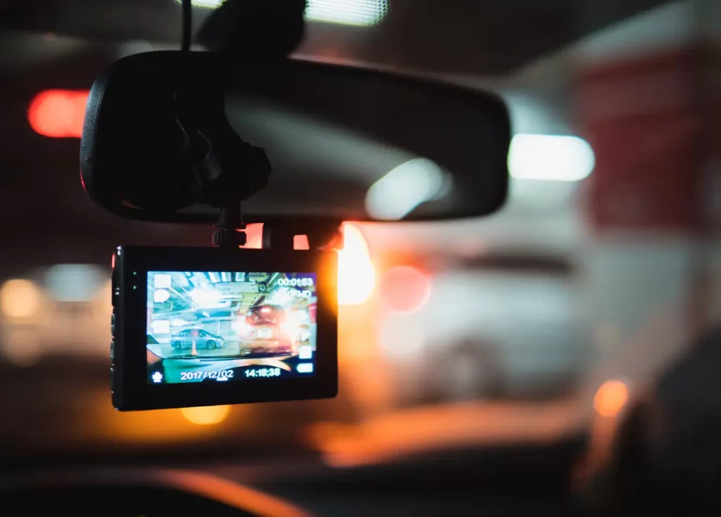 A dash camera mounted below a rearview mirror
