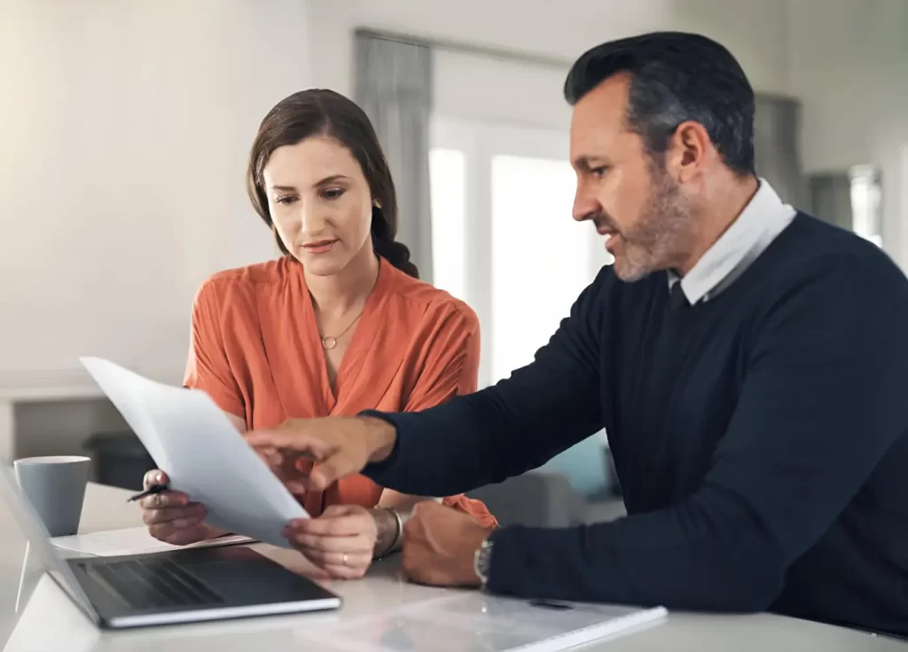 Two people reviewing documents at a desk