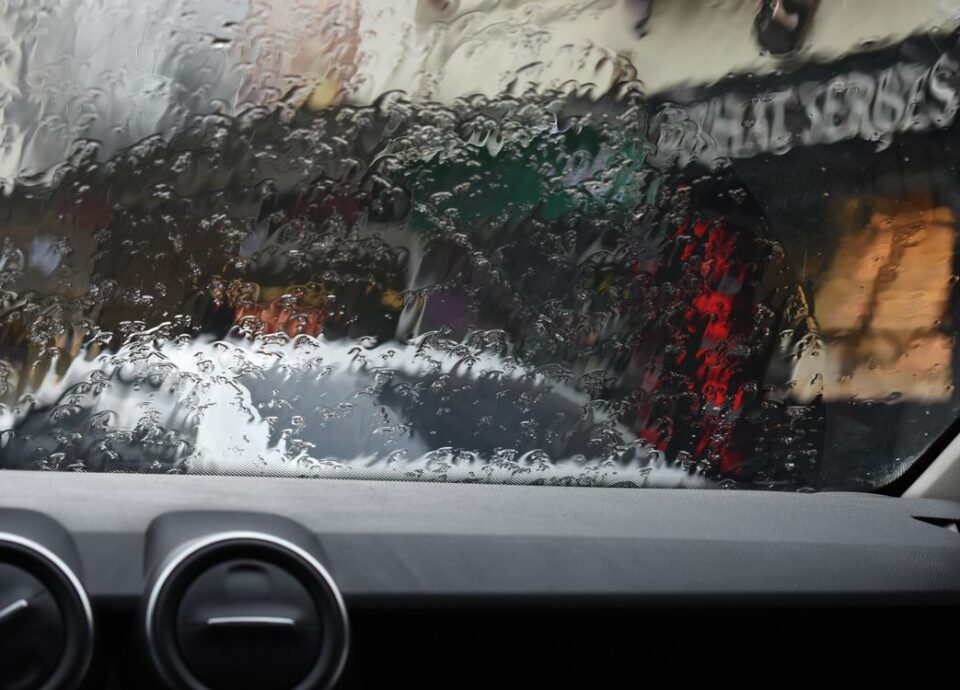 Rain on a car windshield obscuring the street ahead
